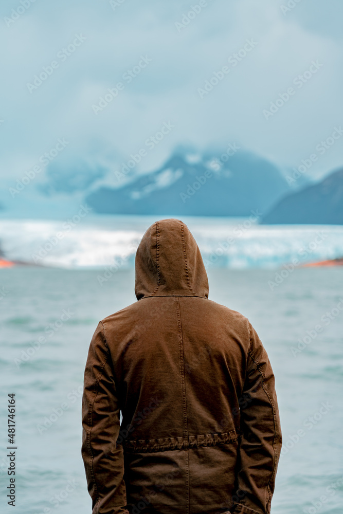person looking out at glacier field in distance person looking out at glacier field in distance