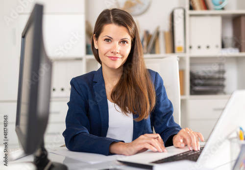 Successful adult business woman using laptop at workplace