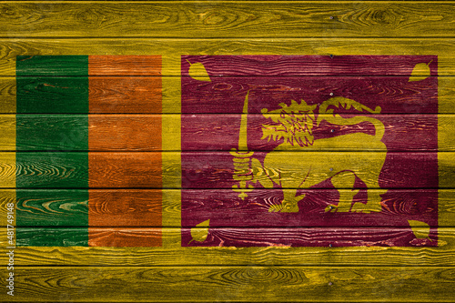 The national flag of Sri Lanka is painted on a camp of even boards nailed with a nail. The symbol of the country.