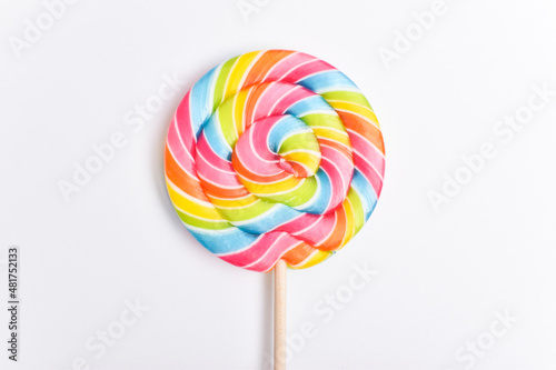 A colored lollipop on a stick. Sweet dessert. Confectionery background. Copy space. Flat lay, top view