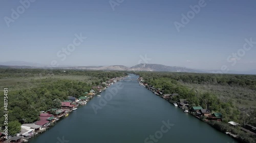 Wallpaper Mural Drone video of the mouth of the Bojana River with Bojana Island and the nomad beach on the sides, restaurants on the shore, frontal shot with the bridge in the background and the mountains. Torontodigital.ca