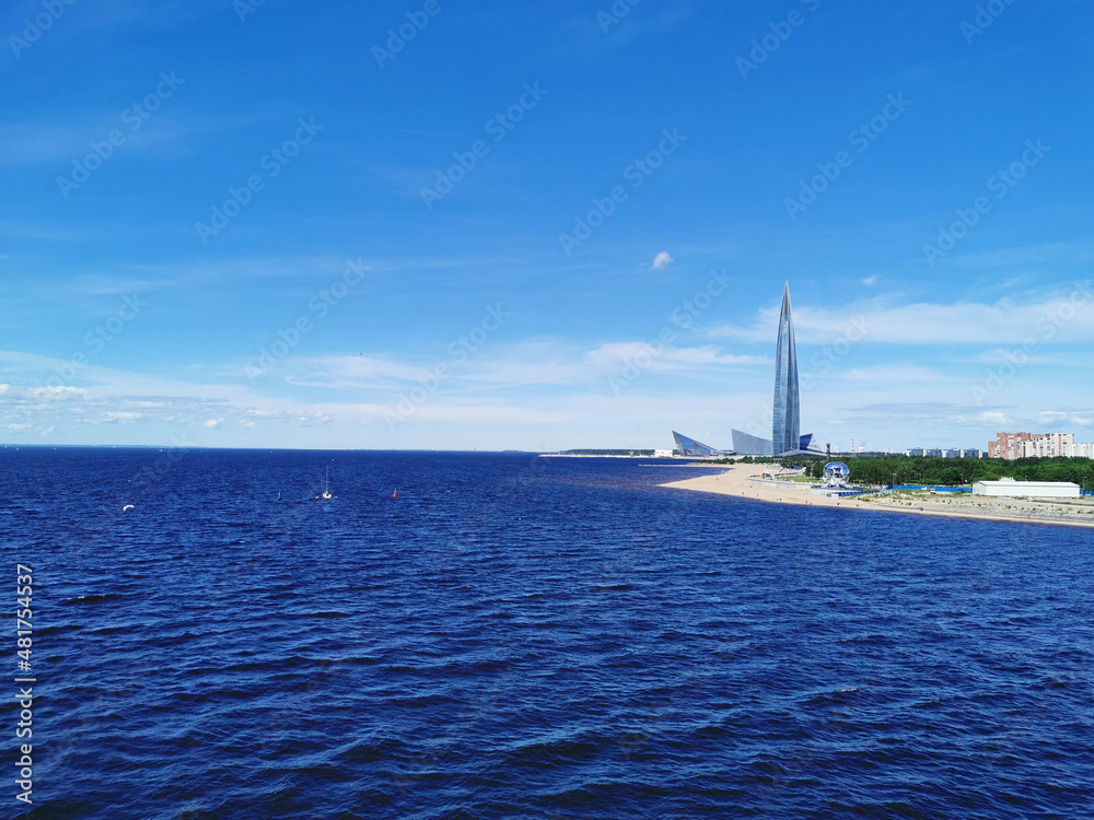 View from the pedestrian bridge of the Gulf of Finland, Lakhta Center and the studio of the Match TV channel in the shape of a football in the park of the 300th anniversary of St. Petersburg