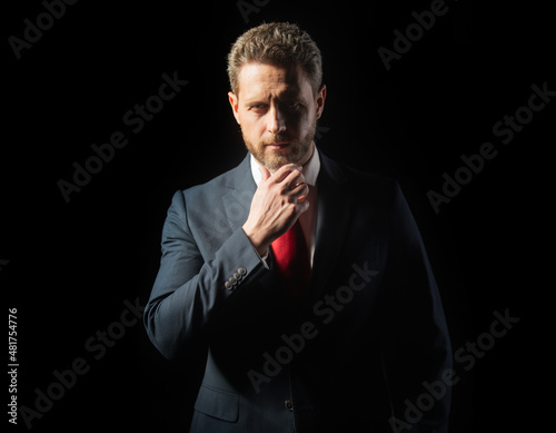 Portrait of an elegant handsome business man isolated on black. Handsome thoughtful middle-aged businessman. People, business, fashion and clothing concept, closeup of man in suit and necktie.