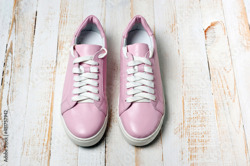 Light pink faux leather shoes laced with laces. Close-up shot.
