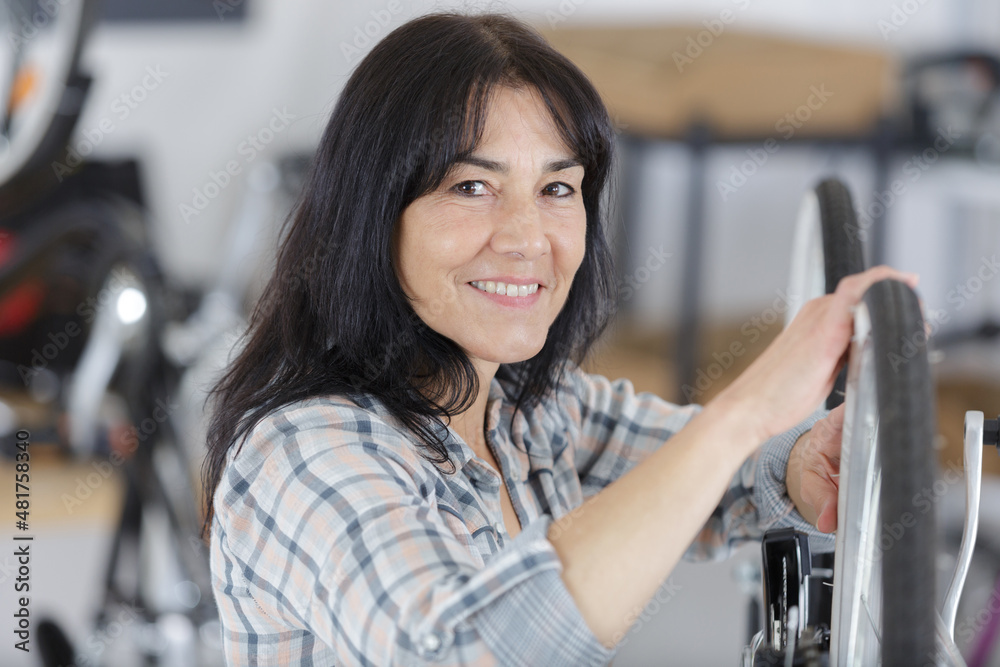 woman checking her bike at home woman checking her bike at home