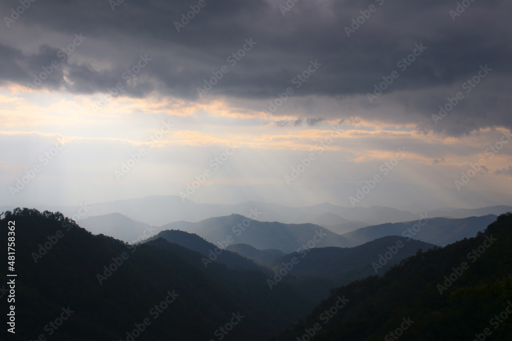 heavenly light and silhouette layers of mountain and cloudy with copy space , background