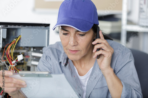 mature woman fixing a computer photo