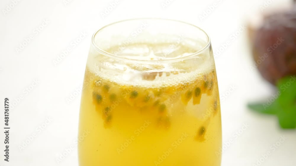 Making delicious passion fruit with sparkling carbonated water on white table background.