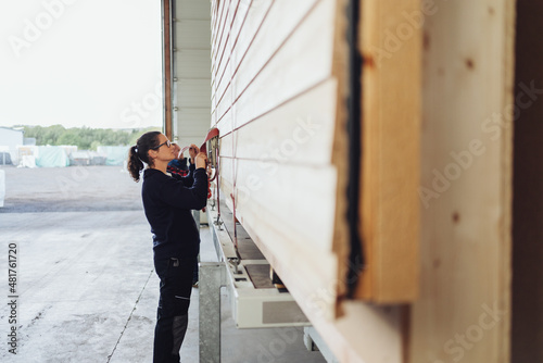Female worker in a woodworking factory adjusting tie downs photo