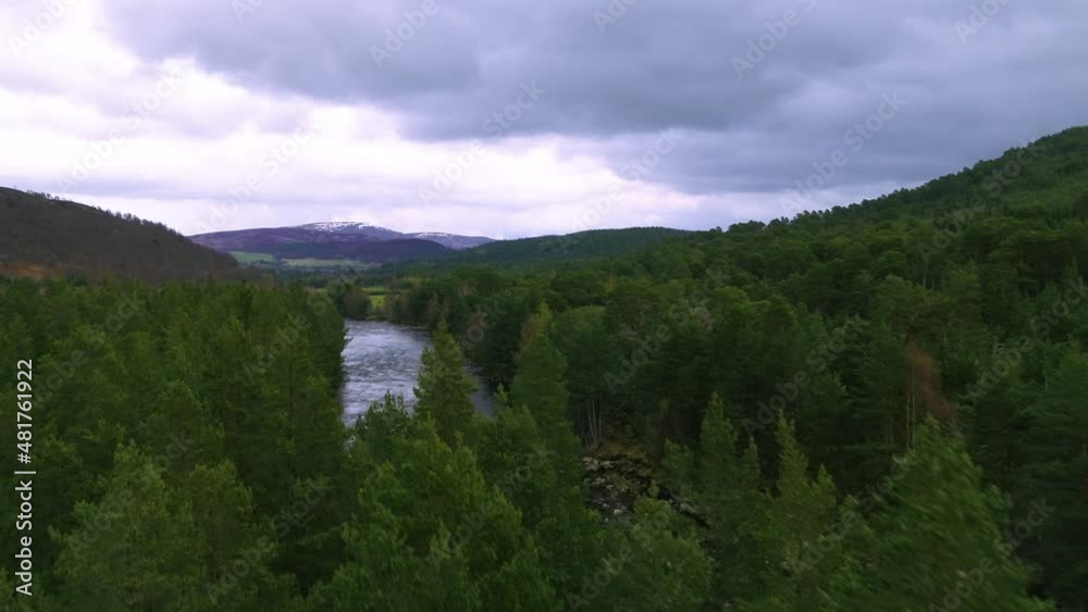 Aerial drone rising up through trees to reveal river in Scottish Highlands Aerial drone rising up through trees to reveal river in Scottish Highlands