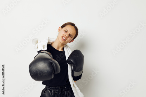 athletic woman in boxing gloves in black pants and a T-shirt isolated background