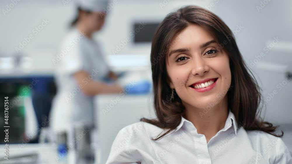 Closeup smiling beautiful brunette young woman sitting dentistry chair with positive emotion Closeup smiling beautiful brunette young woman sitting dentistry chair with positive emotion