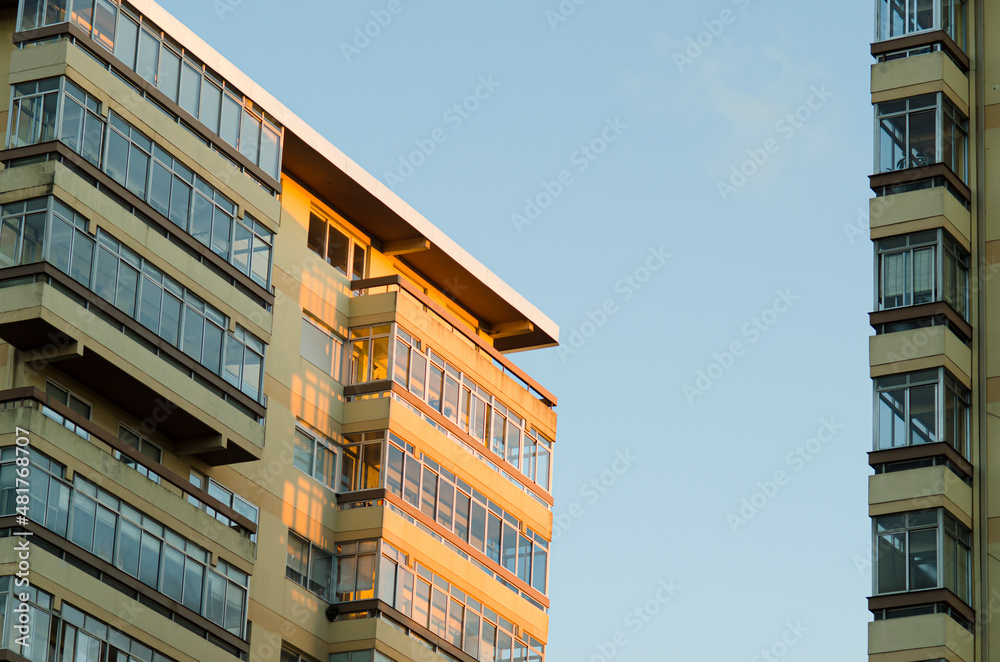 Family residential buildings with some enclosed balconies illuminated by the afternoon sun.