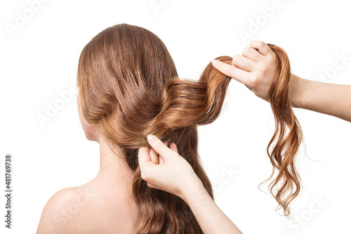Stylist hands form hairstyle on beautiful hair isolated on white