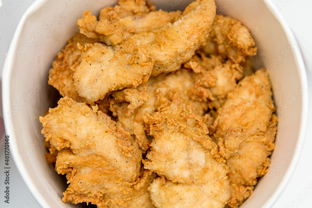 Breaded chicken fillet in bucket. fried chicken strips with take a way bucket Breaded chicken fillet in bucket. fried chicken strips with take a way bucket