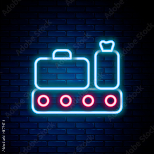Glowing neon line Airport conveyor belt with passenger luggage, suitcase, bag, baggage icon isolated on brick wall background. Colorful outline concept. Vector