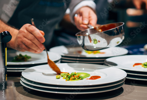 Canvas Print Professional chef arranging food plate with meat and vegetables