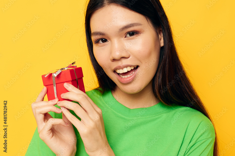 Charming young Asian woman in green T-shirts with a small gift box Lifestyle unaltered Charming young Asian woman in green T-shirts with a small gift box Lifestyle unaltered