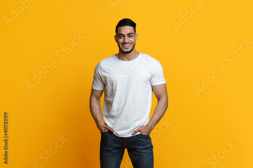 Hot arabic guy smiling on yellow studio background