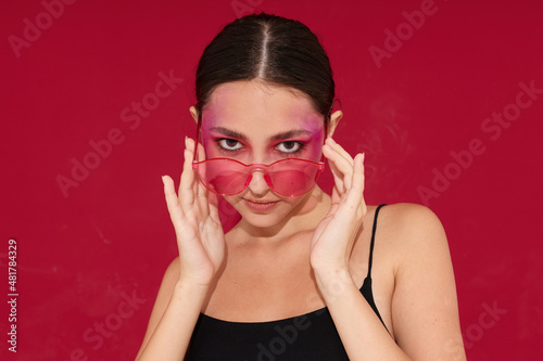 Sexy brunette woman in pink glasses makeup emotions cosmetics isolated background unaltered