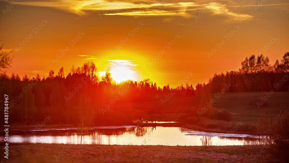 A time-lapse on a sunset above the forest. Lake lies in front of the forest A time-lapse on a sunset above the forest. Lake lies in front of the forest