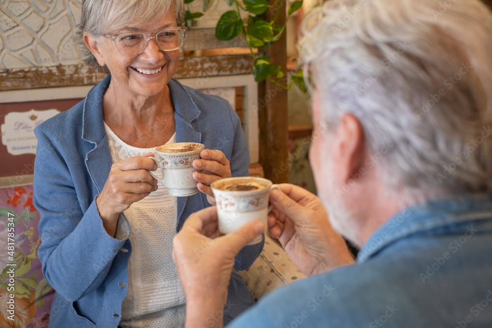 Adult senior couple in coffee shop having breakfast together drinking coffee and cappuccino looking in the eyes. Two attractive smiling elderly people enjoying retirement and stay together. Adult senior couple in coffee shop having breakfast together drinking coffee and cappuccino looking in the eyes. Two attractive smiling elderly people enjoying retirement and stay together.