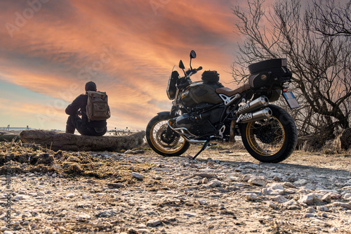 Fototapeta Naklejka Na Ścianę i Meble -  Sunset background with motorcycle and biker relaxing 