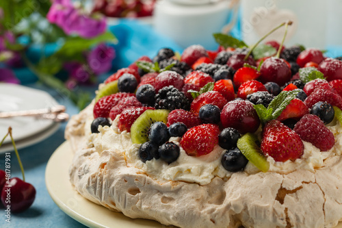 Meringue Pavlova cake with fresh fruit. Front view.