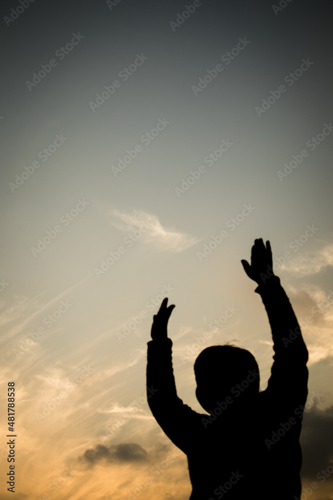 Silhouette of a boy in-front of evening sky.