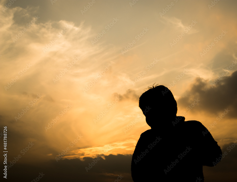 Fototapeta premium Silhouette of a boy in-front of evening sky.
