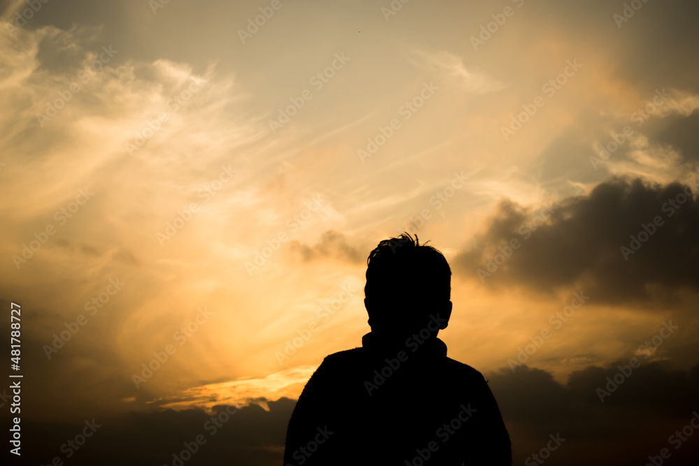 Silhouette of a boy in-front of evening sky.