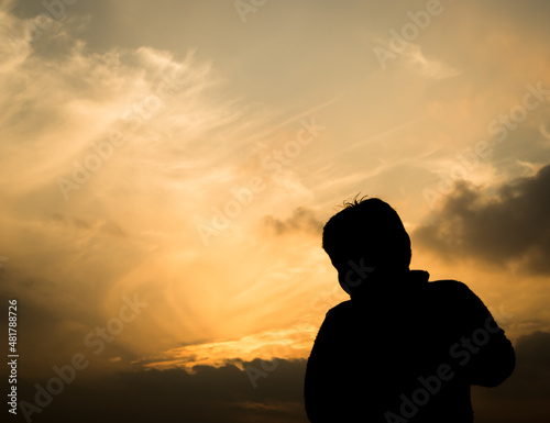 Silhouette of a boy in-front of evening sky.