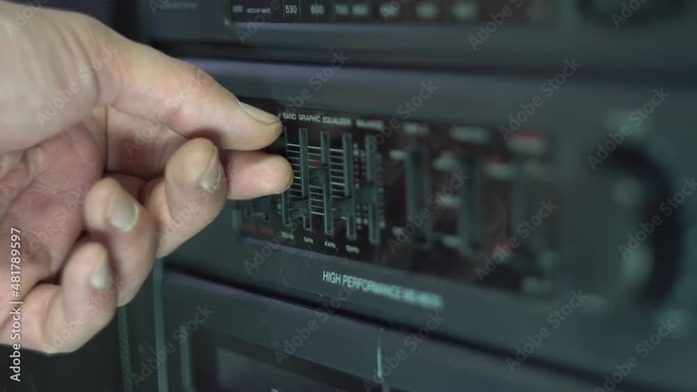 Equalizer setting. Cassette recorder. Finger. Dark body. Retro electronics. Old fashioned design. Analog control. Close-up. Equalizer setting. Cassette recorder. Finger. Dark body. Retro electronics. Old fashioned design. Analog control. Close-up.
