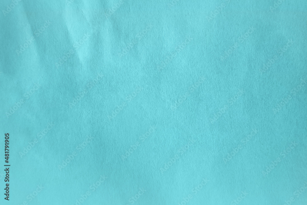 Moderate cyan soft blue color tone paint on creased wrap recyclable organic paper texture to be use as mockup luxury design for packaging minimalistic background