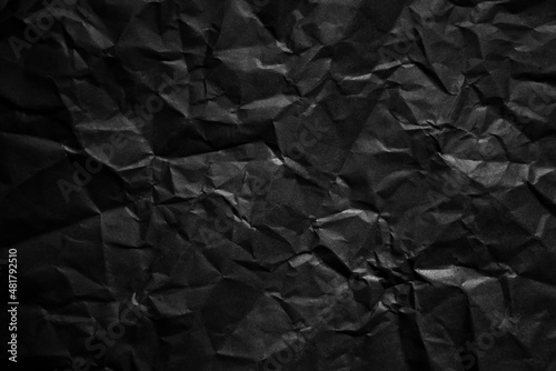 Textured crumpled black paper background.