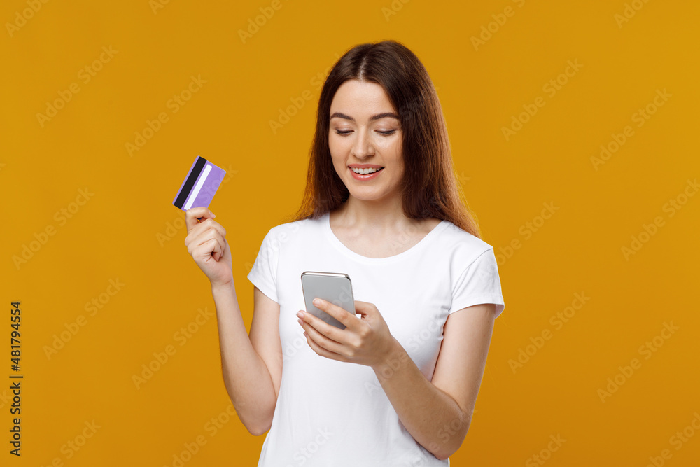Naklejka premium Happy young lady with smartphone and credit card