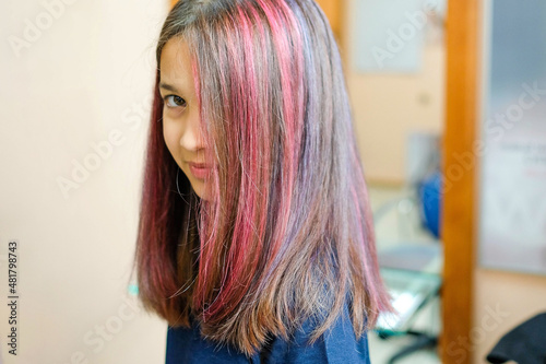 A young girl with dyed colored strands of hair. Focus on hair