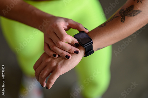 Woman in sportswear checks fitness and health tracking on her smartwatch after training © Zamrznuti tonovi