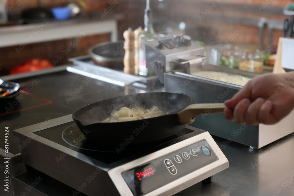 Professional chef frying onion in restaurant kitchen, closeup Professional chef frying onion in restaurant kitchen, closeup