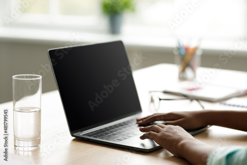 Wallpaper Mural Teenage african american school girl typing on laptop with mockup blank screen and studying Torontodigital.ca