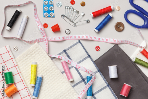 Top view of sewing tools and accessories.Fabric and threads on a gray background.
