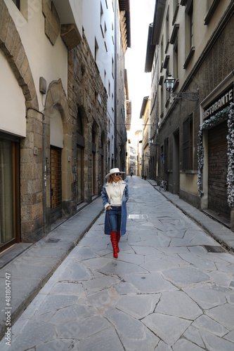 Damska stylizacja łącząca dżins z białym kapeluszem i czerwonymi kozakami. Wiosna 2022 © marriaci_photo