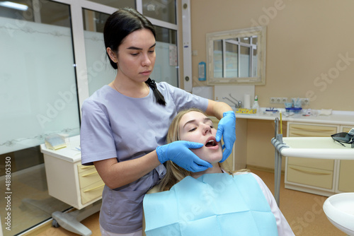 Beautiful young woman doing a dental examination in the dental office.