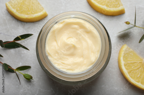 Jar of organic cream and lemon slices on light marble table  flat lay