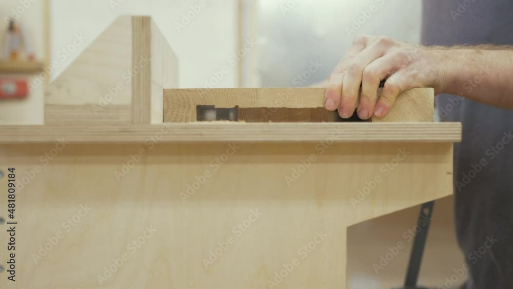 Carpenter cutting recess in white oak slab on router table Carpenter cutting recess in white oak slab on router table