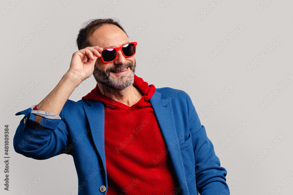 Obraz premium Stylish senior man peeking through sunglasses