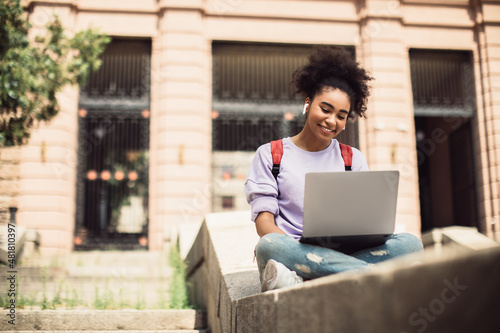 Black Student Girl Sitting With Laptop Learning And Communicating Outdoors photo