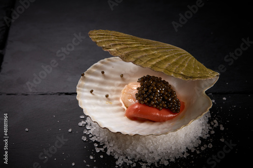 The scallop whith black caviar on the satl