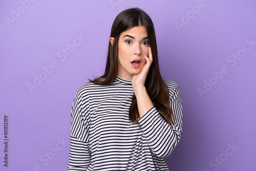 Young Brazilian woman isolated on purple background surprised and shocked while looking right