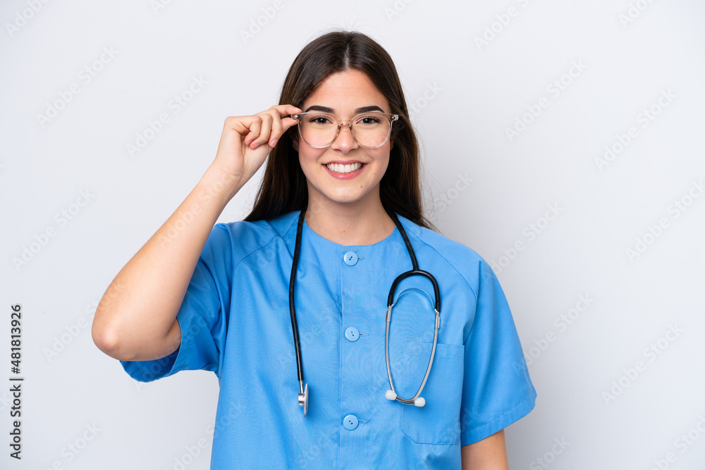 Young Brazilian nurse woman isolated on white background with glasses and surprised Young Brazilian nurse woman isolated on white background with glasses and surprised